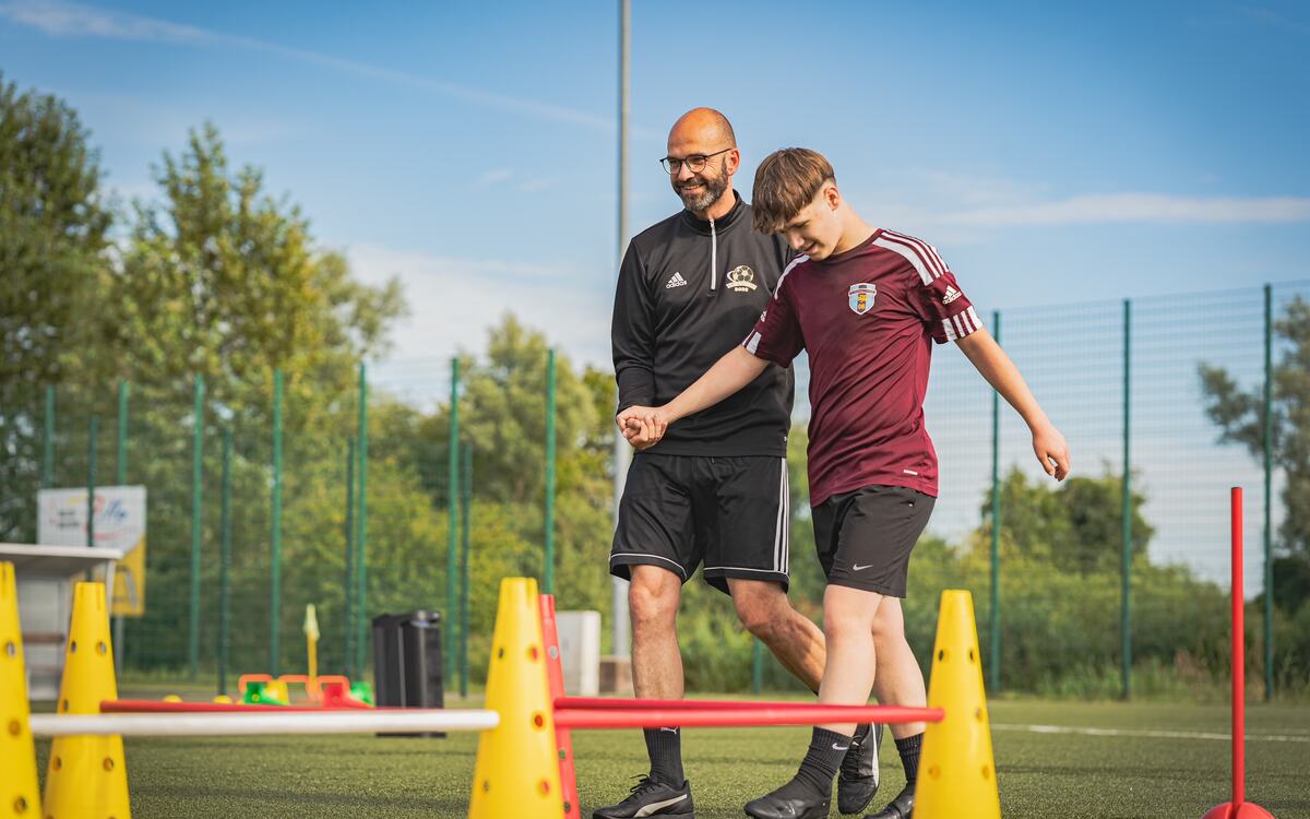 Alexander Bode zeigt einem Jugendspieler eine Koordinationsübung